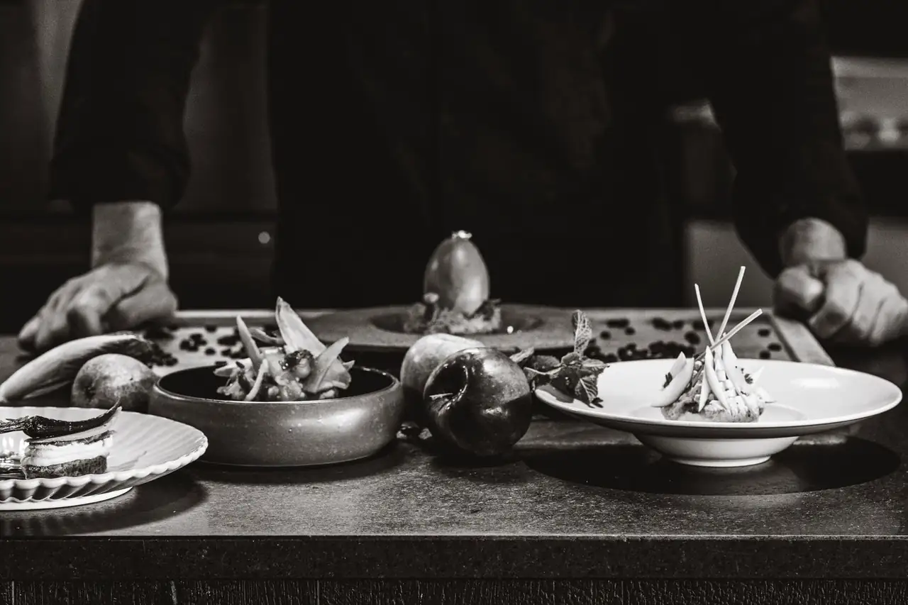 Chef meticulously plating a signature dish at Frostlumen Leon